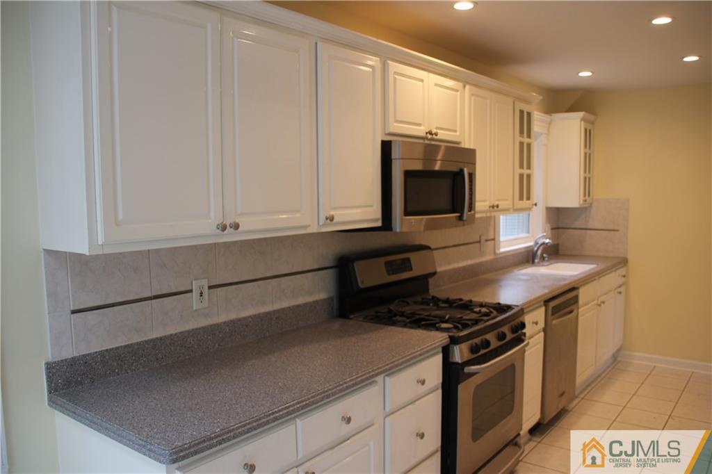 21 Channing Road East Brunswick, NJ 08816 - Photo 3 of 25 a kitchen with stainless steel appliances a stove a microwave and a sink
