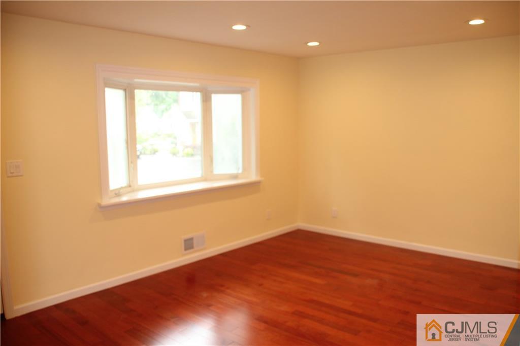 21 Channing Road East Brunswick, NJ 08816 - Photo 6 of 25 a view of an empty room with wooden floor and a window