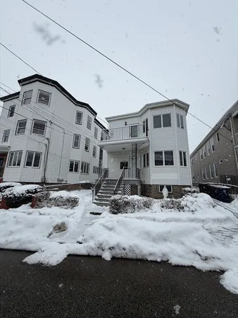 a view of a white house with snow on the road