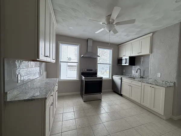 a kitchen with a stove a sink a microwave a refrigerator and cabinets