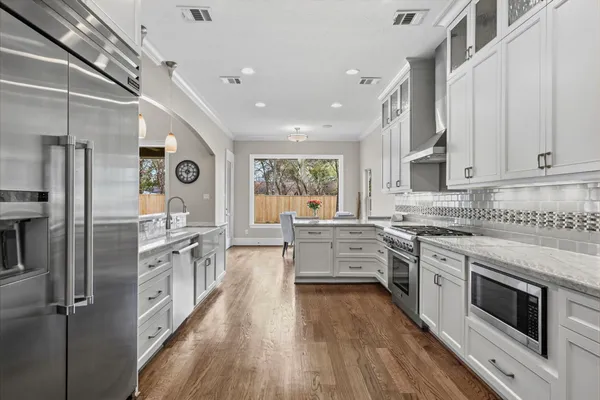 a kitchen with stainless steel appliances granite countertop hardwood floor sink stove and refrigerator