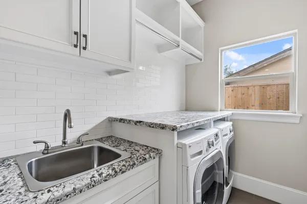 a bathroom with a granite countertop sink a toilet a mirror and shower