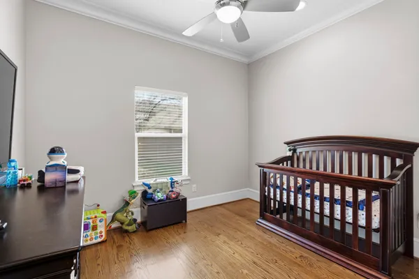 a bedroom with a bed a chandelier and a dresser