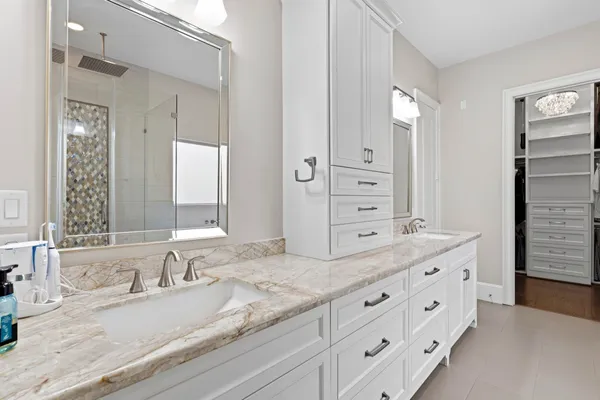 a en suite bathroom with a granite countertop sink and a mirror