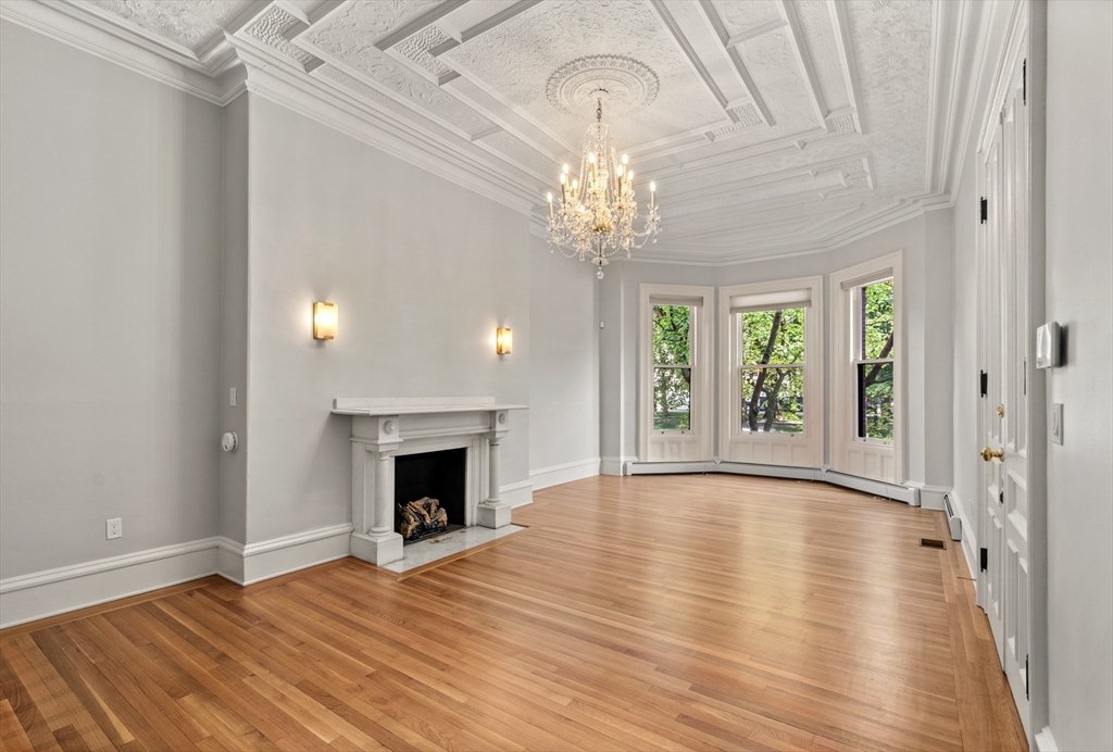 wooden floor fireplace and windows in an empty room