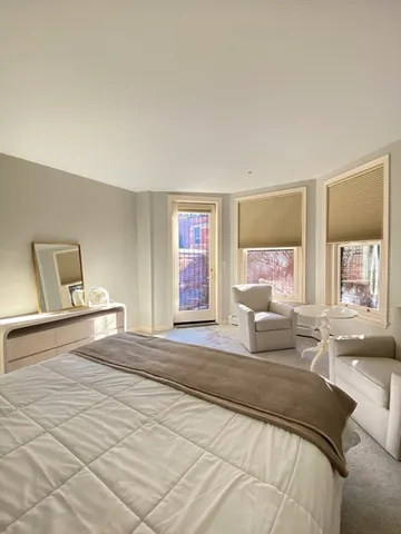a spacious bedroom with a bed and glass walk in closet