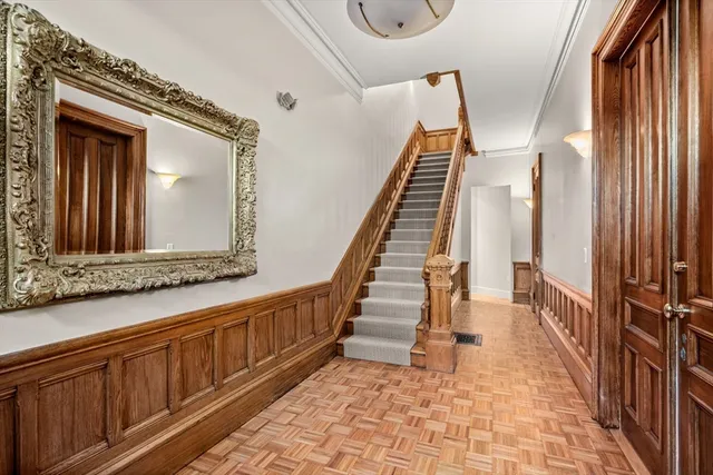 a view of a hallway with wooden floor and staircase