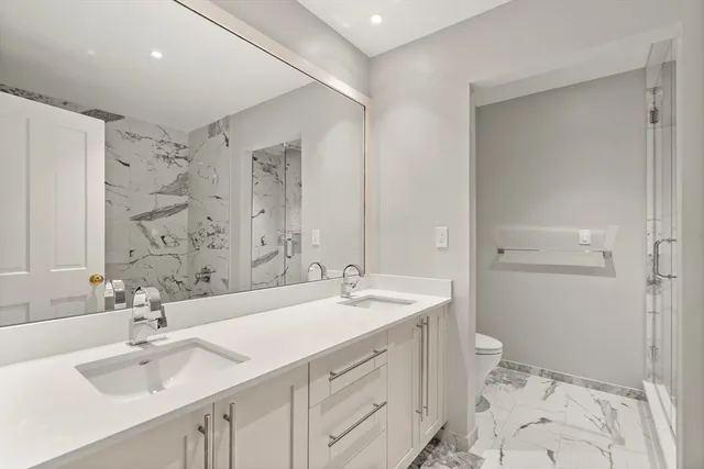 a bathroom with a sink a toilet and shower