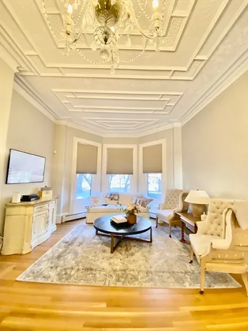 a living room with fireplace furniture and a potted plant