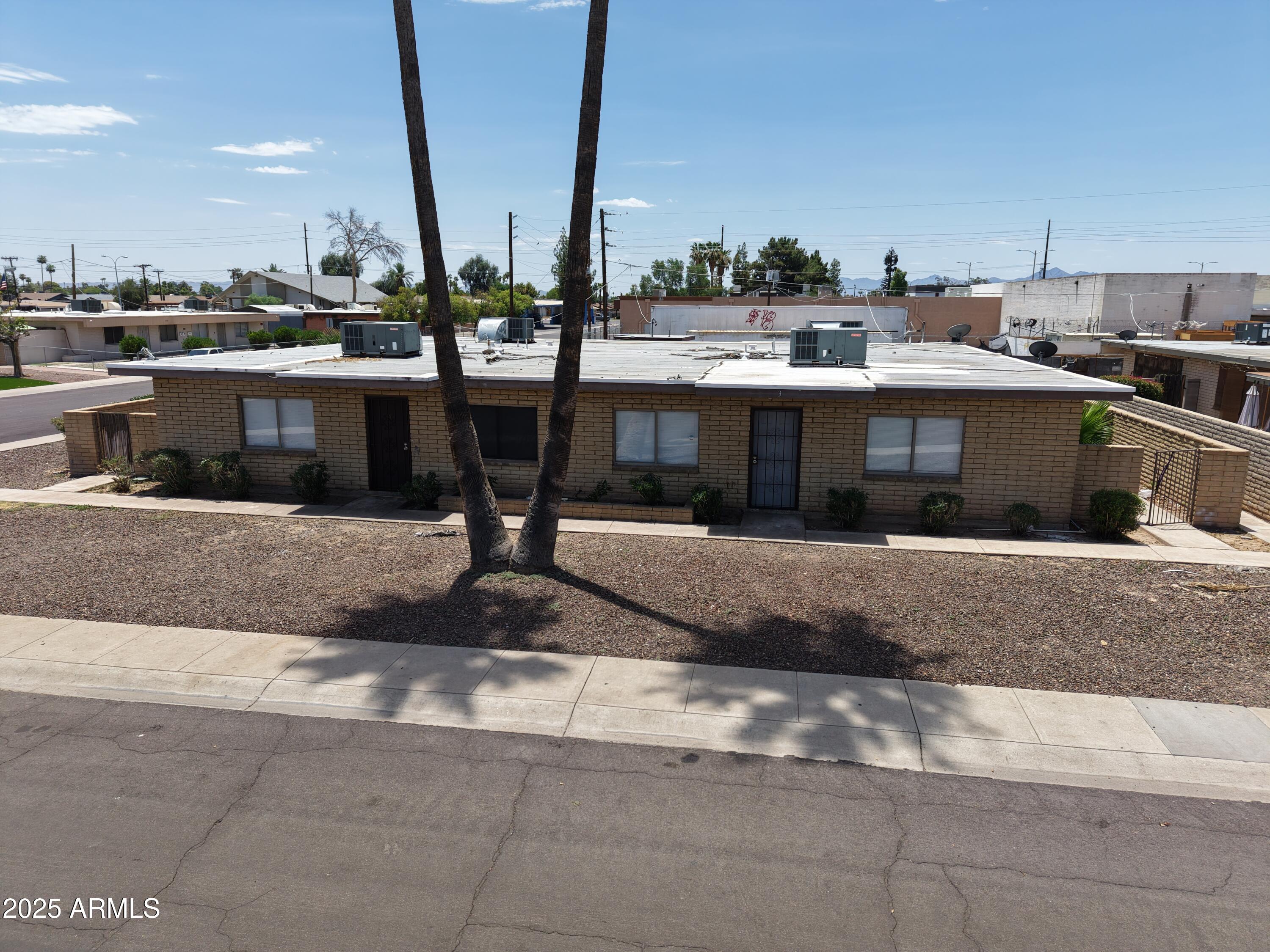 6605 West Pasadena Avenue Glendale, AZ 85301 - Photo 2 of 4 a view of a building with a yard and palm trees