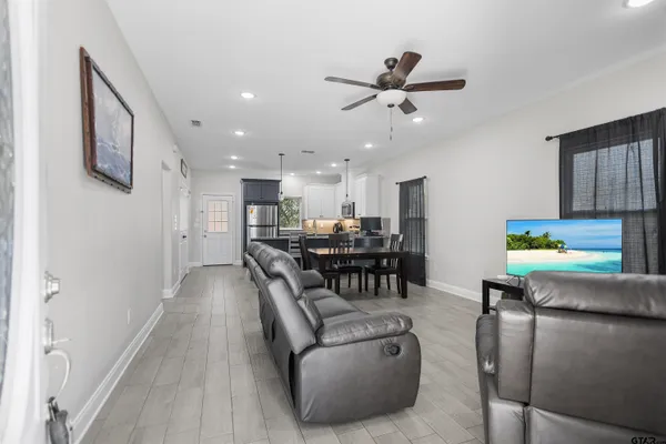 a living room with furniture and a dining table with kitchen view