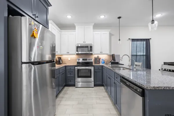 a kitchen with granite countertop a refrigerator and a sink