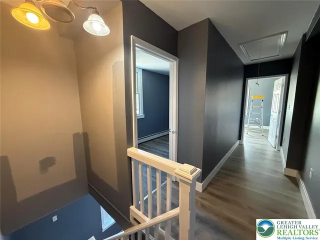 a view of a hallway with wooden floor and staircase