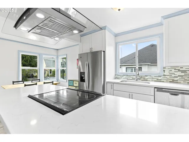 a kitchen with stainless steel appliances granite countertop a sink refrigerator and window