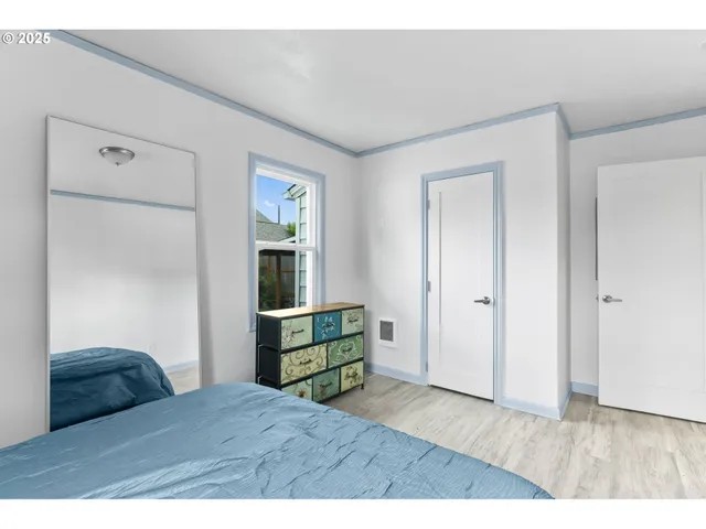 a bedroom with a bed and wooden floor