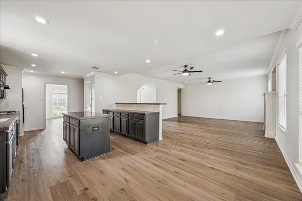 a large kitchen with stainless steel appliances granite countertop a stove and a wooden floors