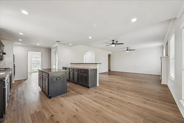 an open kitchen with wooden floor and stainless steel appliances