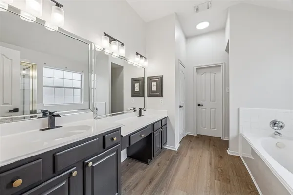 a bathroom with a bathtub a sink and a large window