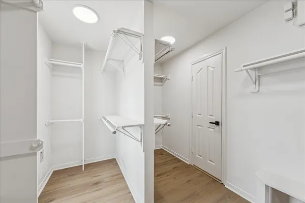 an empty room with wooden floor ceiling fan and windows