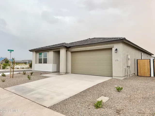 a view of a house with backyard and trees in the background