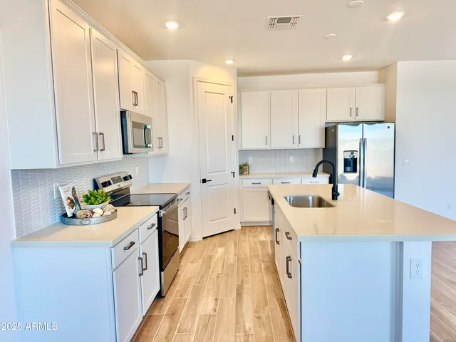 a kitchen with a sink a stove and cabinets