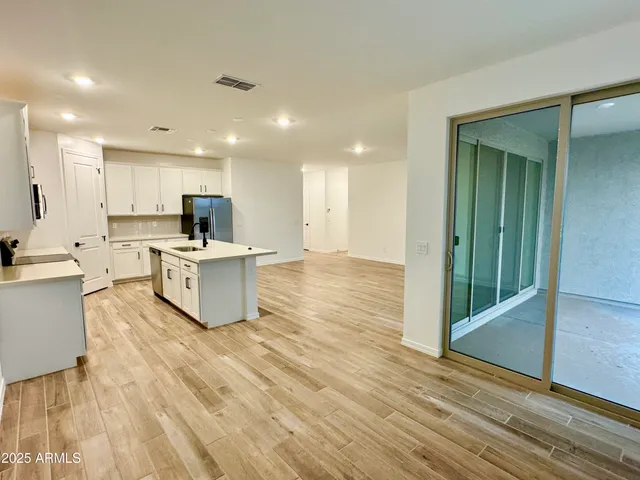 a large kitchen with cabinets and a wooden floor