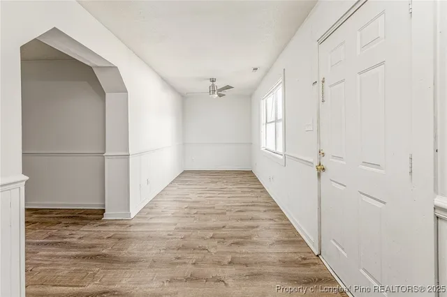 a view of a hallway with wooden floor and staircase