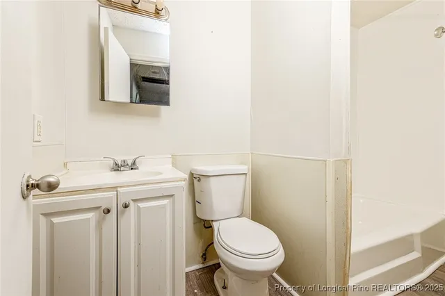 a view of a big room with wooden floor and windows