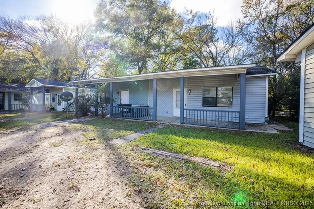 a view of a backyard with a large tree and wooden fence
