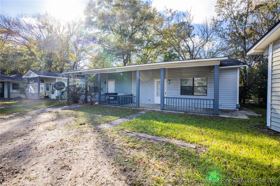 210 South Plymouth Street, Unit 1 Fayetteville, NC 28312 - Photo 3 of 26 a view of a backyard with a large tree and wooden fence