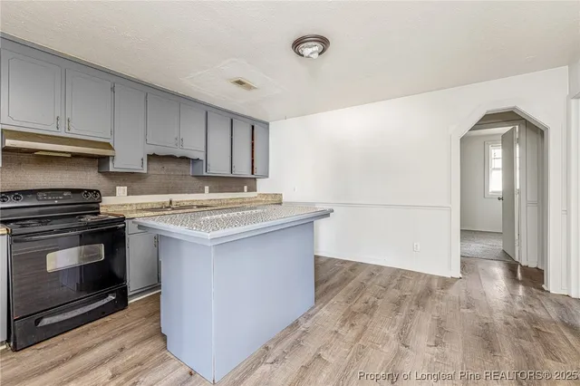 a kitchen with granite countertop a stove and a refrigerator