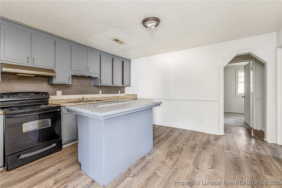 210 South Plymouth Street, Unit 1 Fayetteville, NC 28312 - Photo 6 of 26 a kitchen with granite countertop a stove and a refrigerator