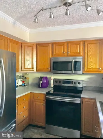 a kitchen with stainless steel appliances a stove a sink and a refrigerator