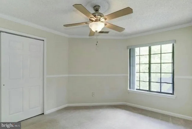 an empty room with a window and a ceiling fan