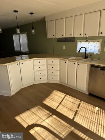 a kitchen with white cabinets and sink
