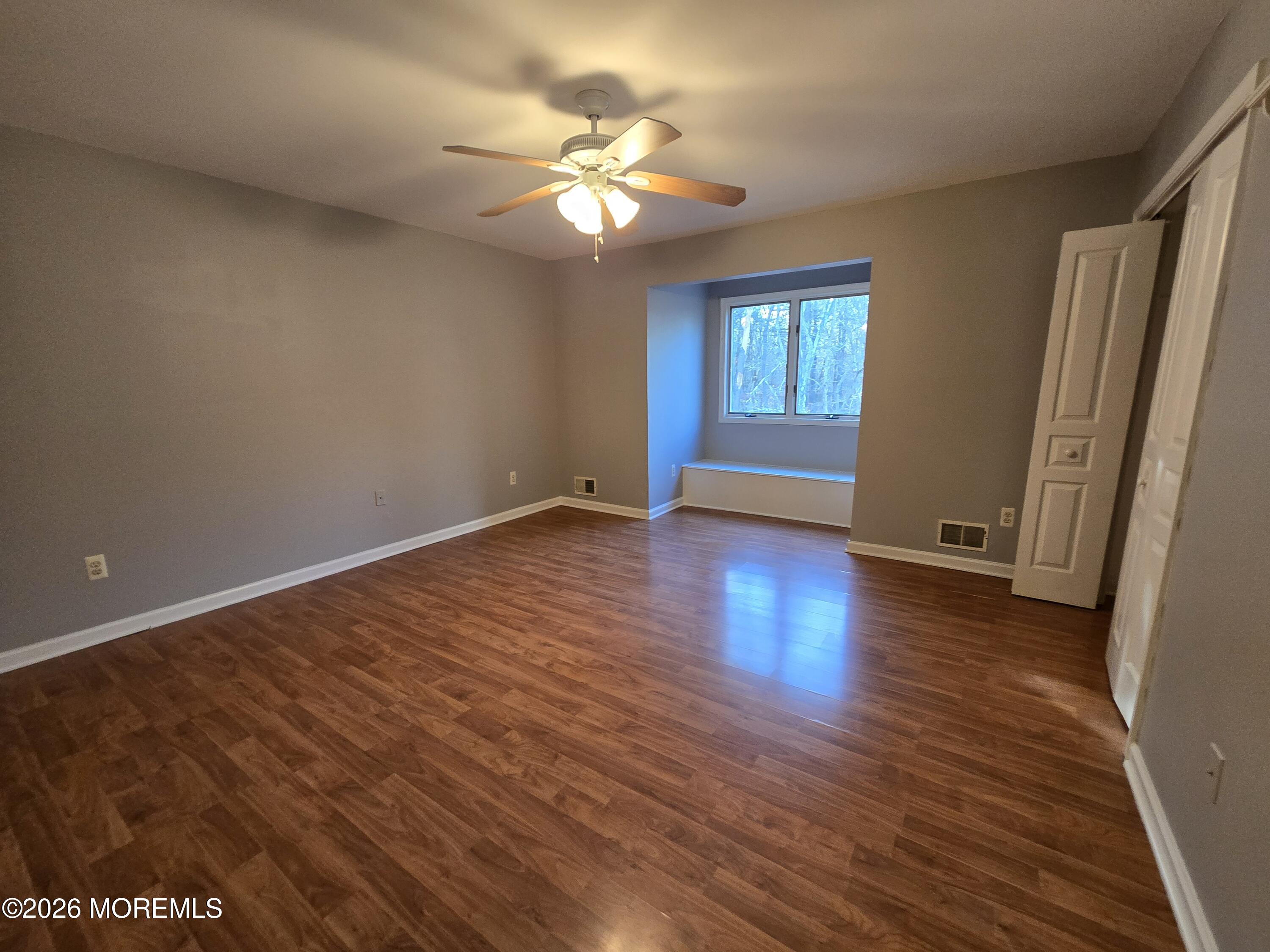 274 Easy Street, Unit RIGHT Howell, NJ 07731 - Photo 13 of 19 a view of an empty room with wooden floor and a window