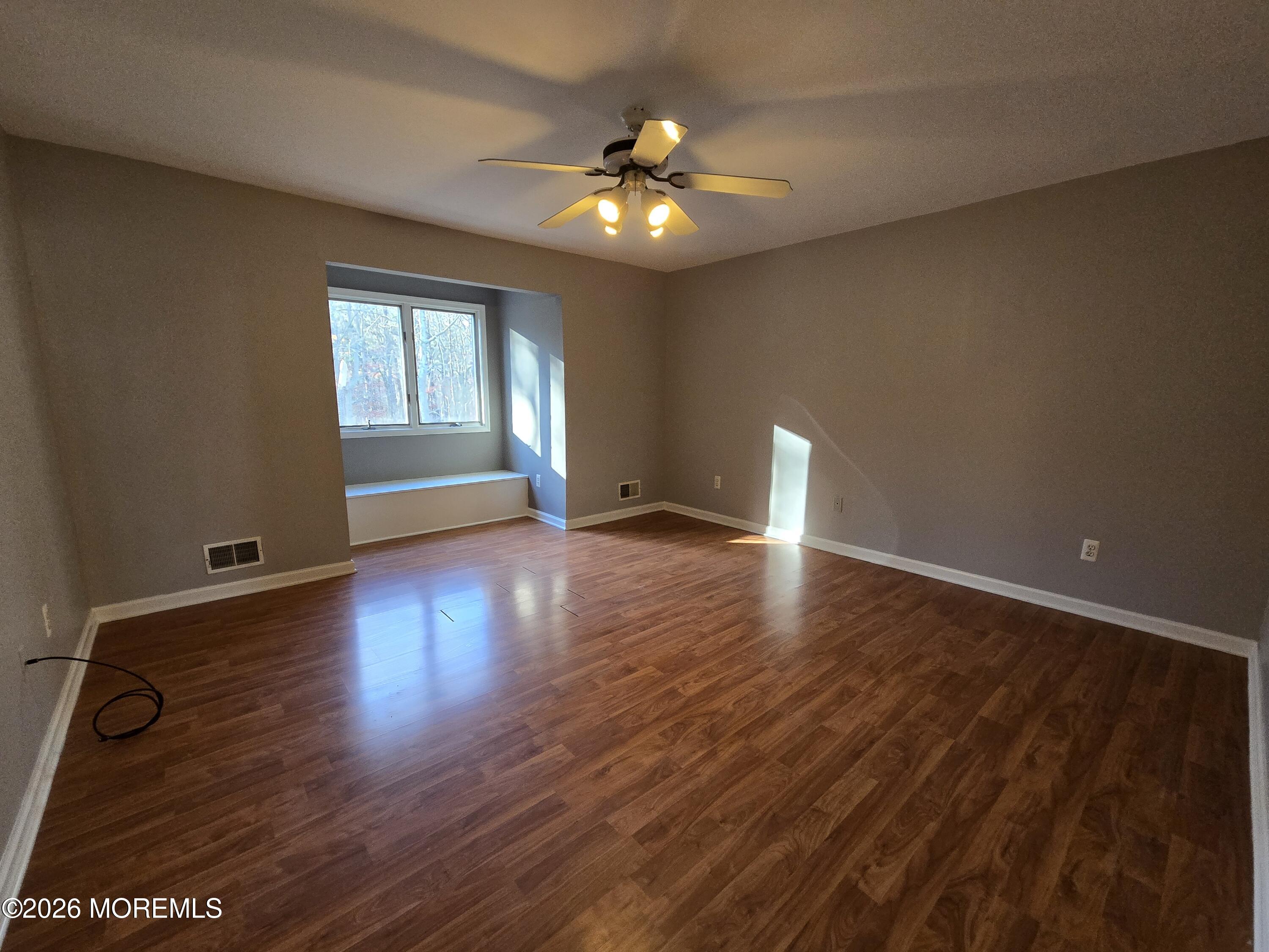 274 Easy Street, Unit RIGHT Howell, NJ 07731 - Photo 15 of 19 a view of an empty room with wooden floor and a window