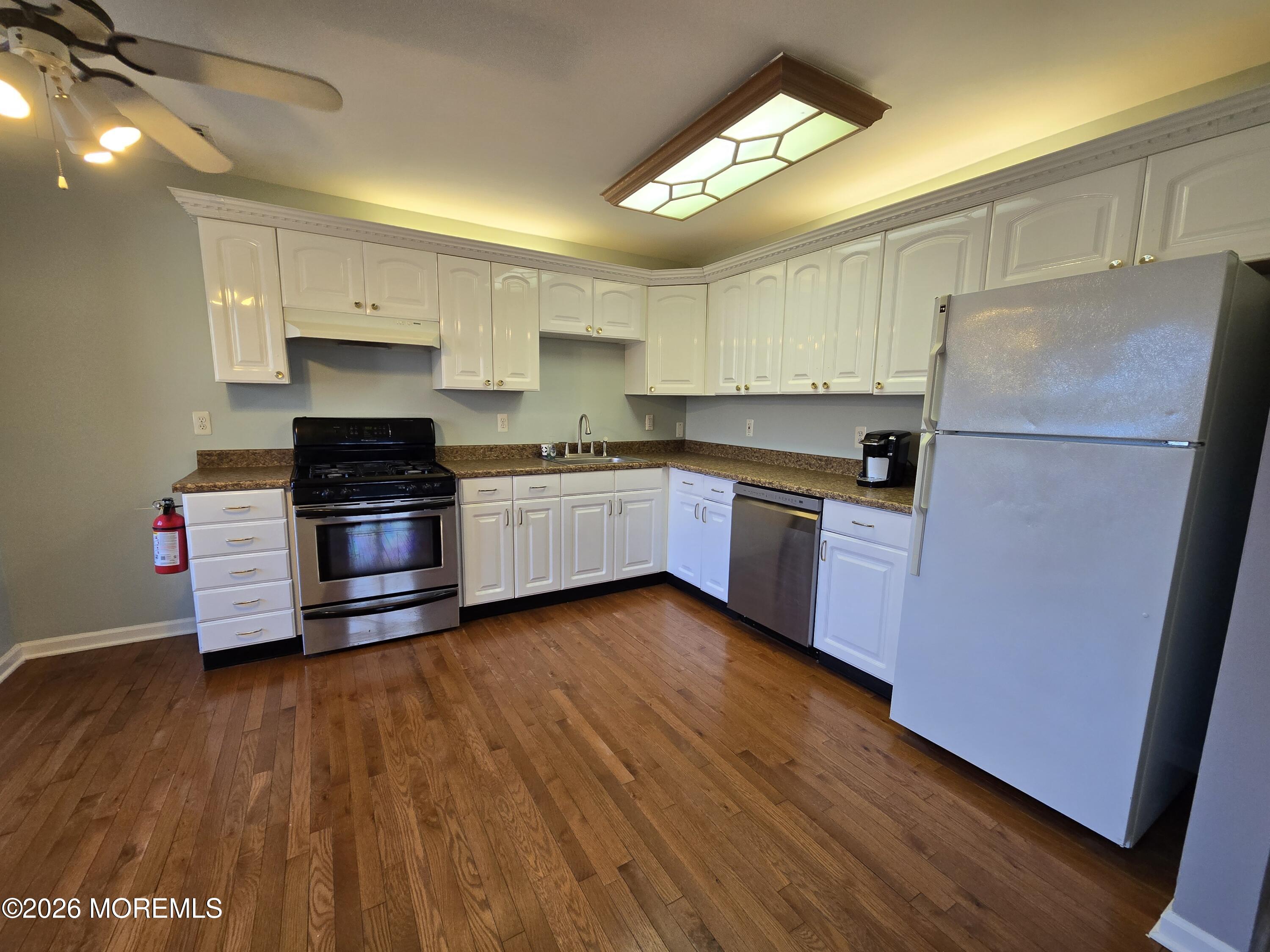 274 Easy Street, Unit RIGHT Howell, NJ 07731 - Photo 5 of 19 a kitchen with granite countertop wooden floors and stainless steel appliances