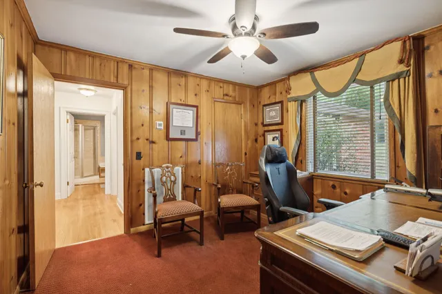 a view of a workspace with furniture and a window
