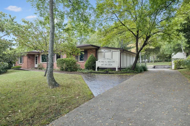 a view of a house with backyard and a tree