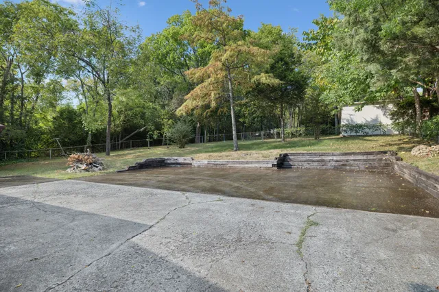 an aerial view of residential house with outdoor space and trees all around