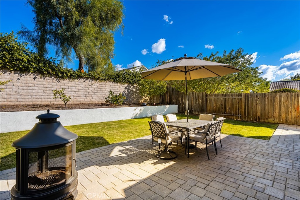 25671 Westover Circle Lake Forest, CA 92630 - Photo 16 of 37 a view of a swimming pool with a table and chairs under an umbrella