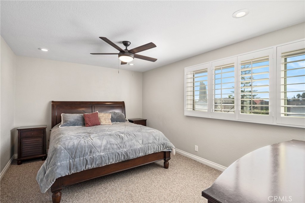 25671 Westover Circle Lake Forest, CA 92630 - Photo 22 of 37 a bedroom with a bed chandelier and a window