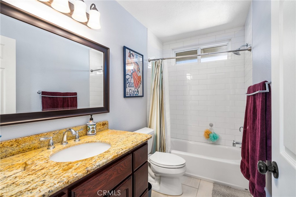 25671 Westover Circle Lake Forest, CA 92630 - Photo 30 of 37 a bathroom with a granite countertop bathtub sink vanity mirror and toilet