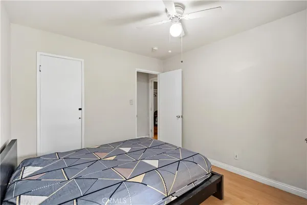 a bedroom with a bed and a chandelier fan