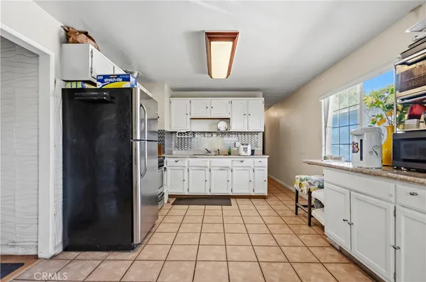 a kitchen with a refrigerator and a stove top oven