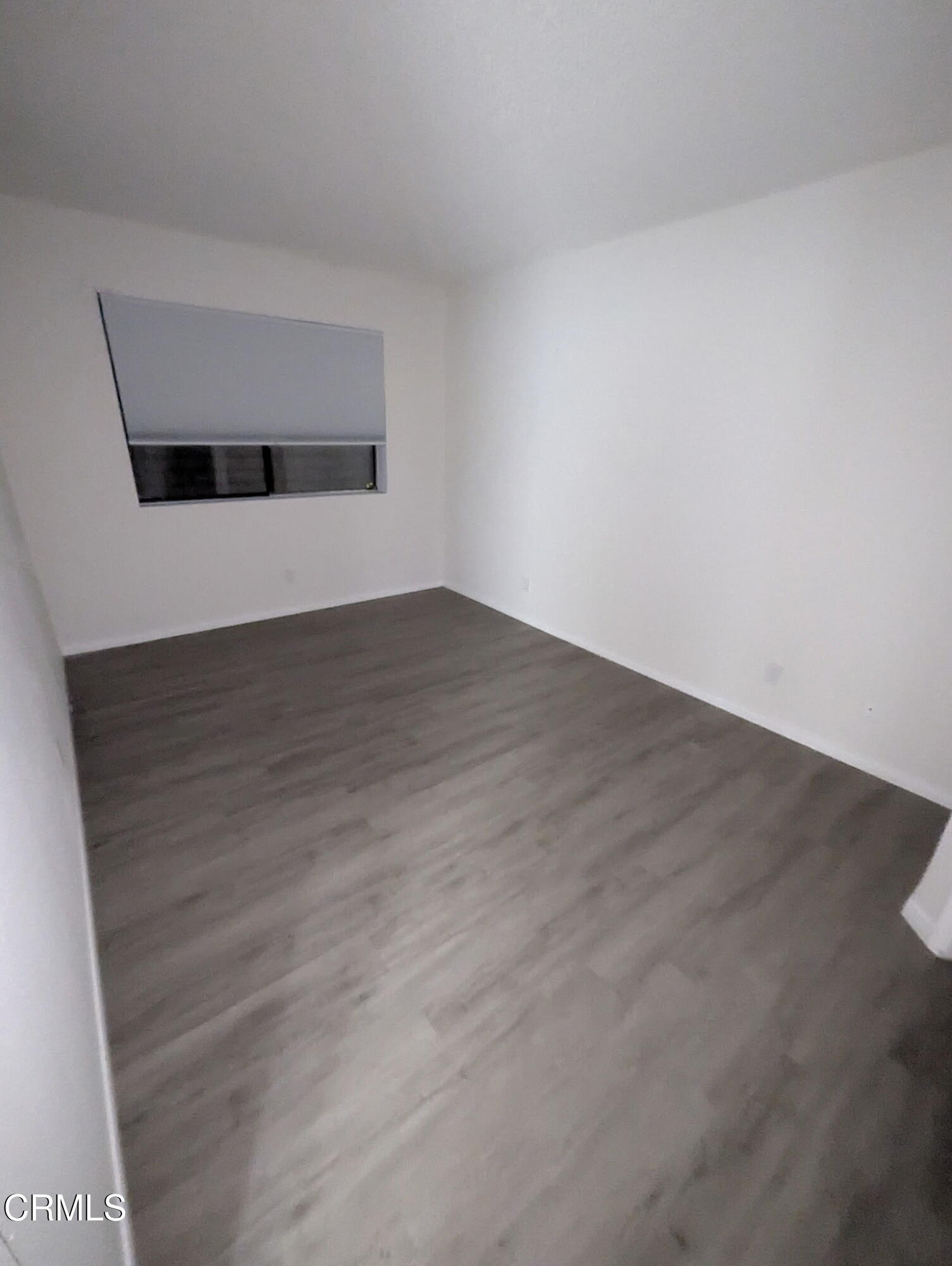 1851 Patricia Avenue, Unit 102 Simi Valley, CA 93065 - Photo 13 of 23 a view of an empty room with wooden floor and a window