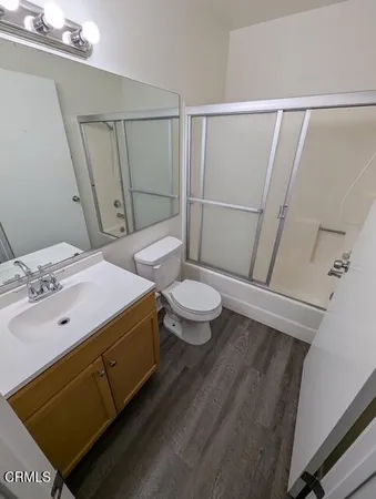 a bathroom with a sink a toilet a mirror and shower
