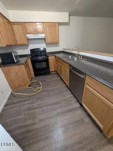 a kitchen with granite countertop a stove and a sink