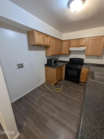 a kitchen with granite countertop a stove and a refrigerator